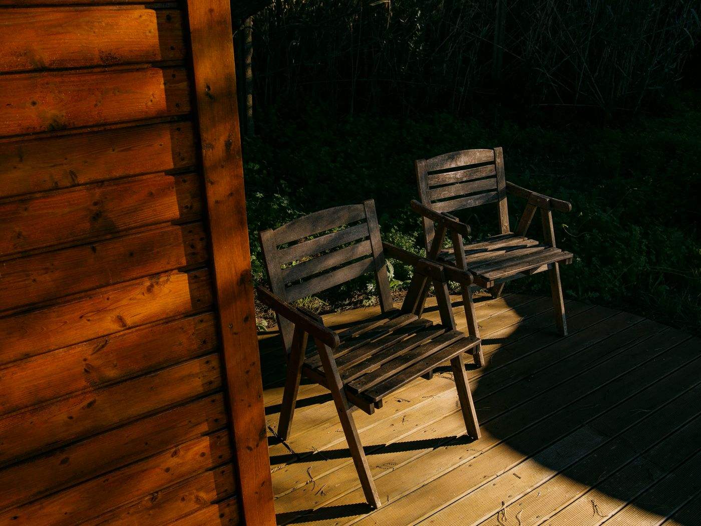 Deck painting Boston MA: freshly finished wood deck with outdoor chairs